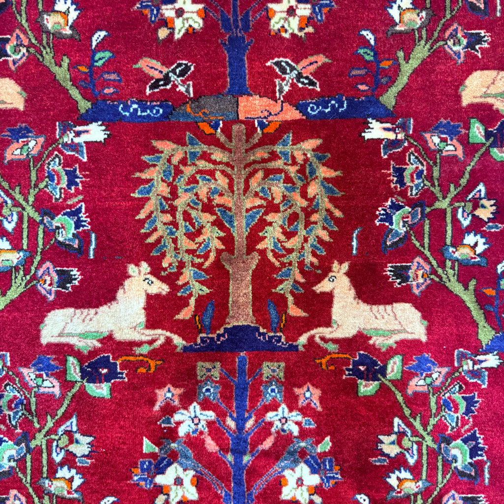 Decorative fabric with tree of life and deer design on a red background