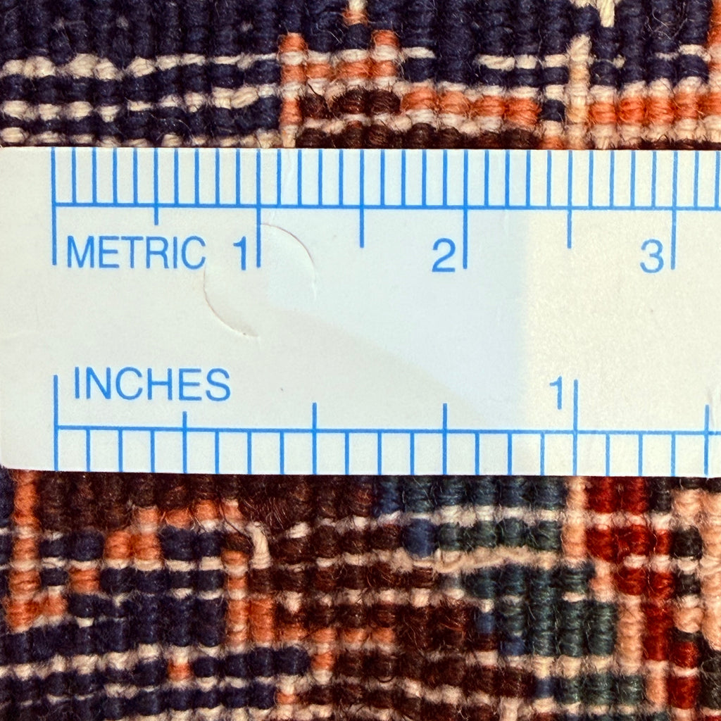 Close-up of a textured fabric with a ruler overlay showing measurements in both metric and inches.