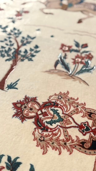 Close-up of a beige carpet with traditional Chinese-style embroidery featuring a dragon, floral motifs, and tree branches in red, blue, and green.