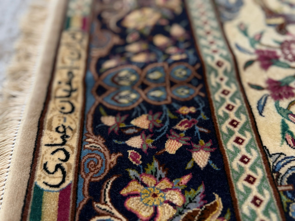 Close-up of a patterned rug with intricate designs and text.