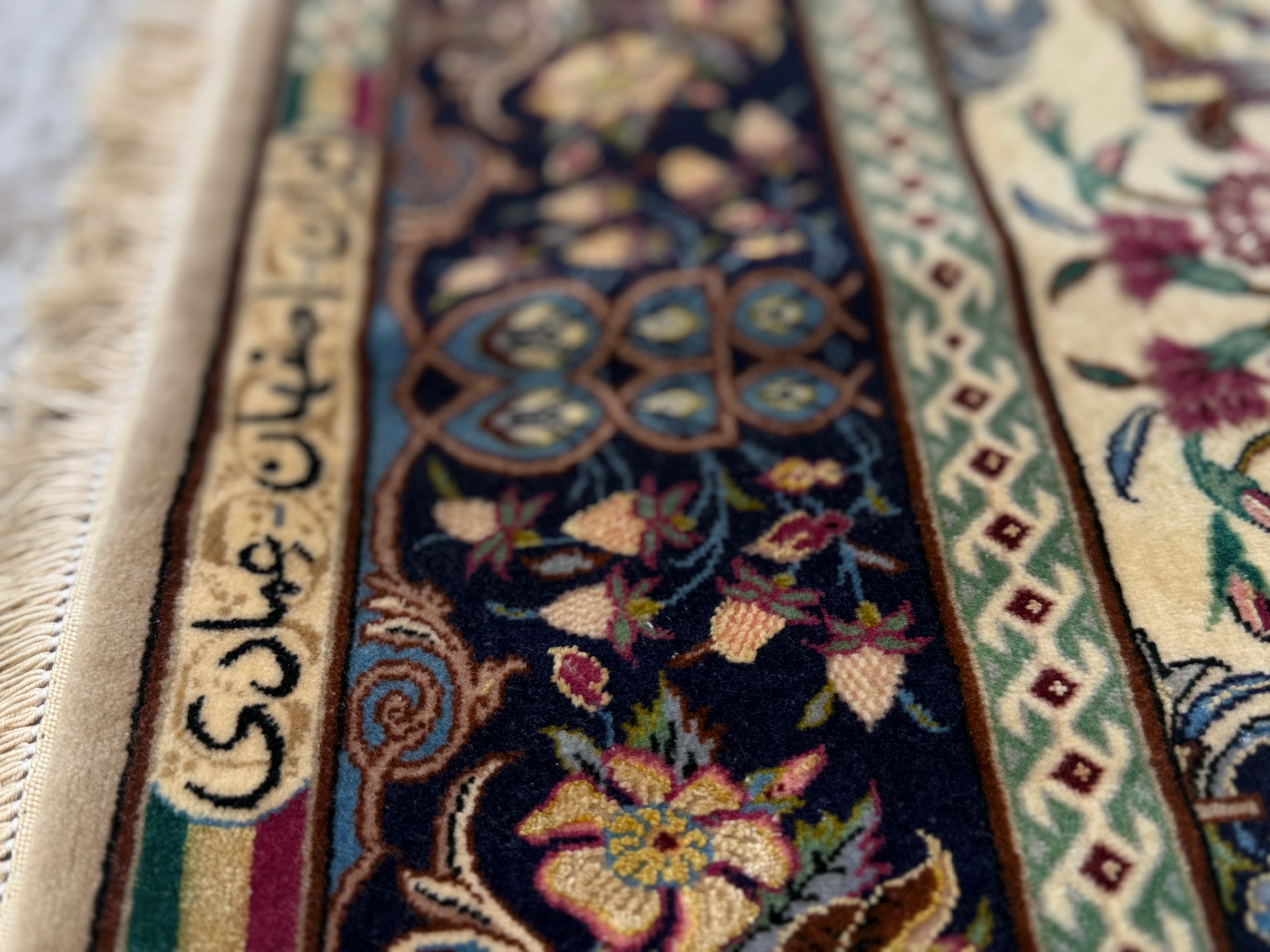 Close-up of a patterned rug with intricate designs and text.