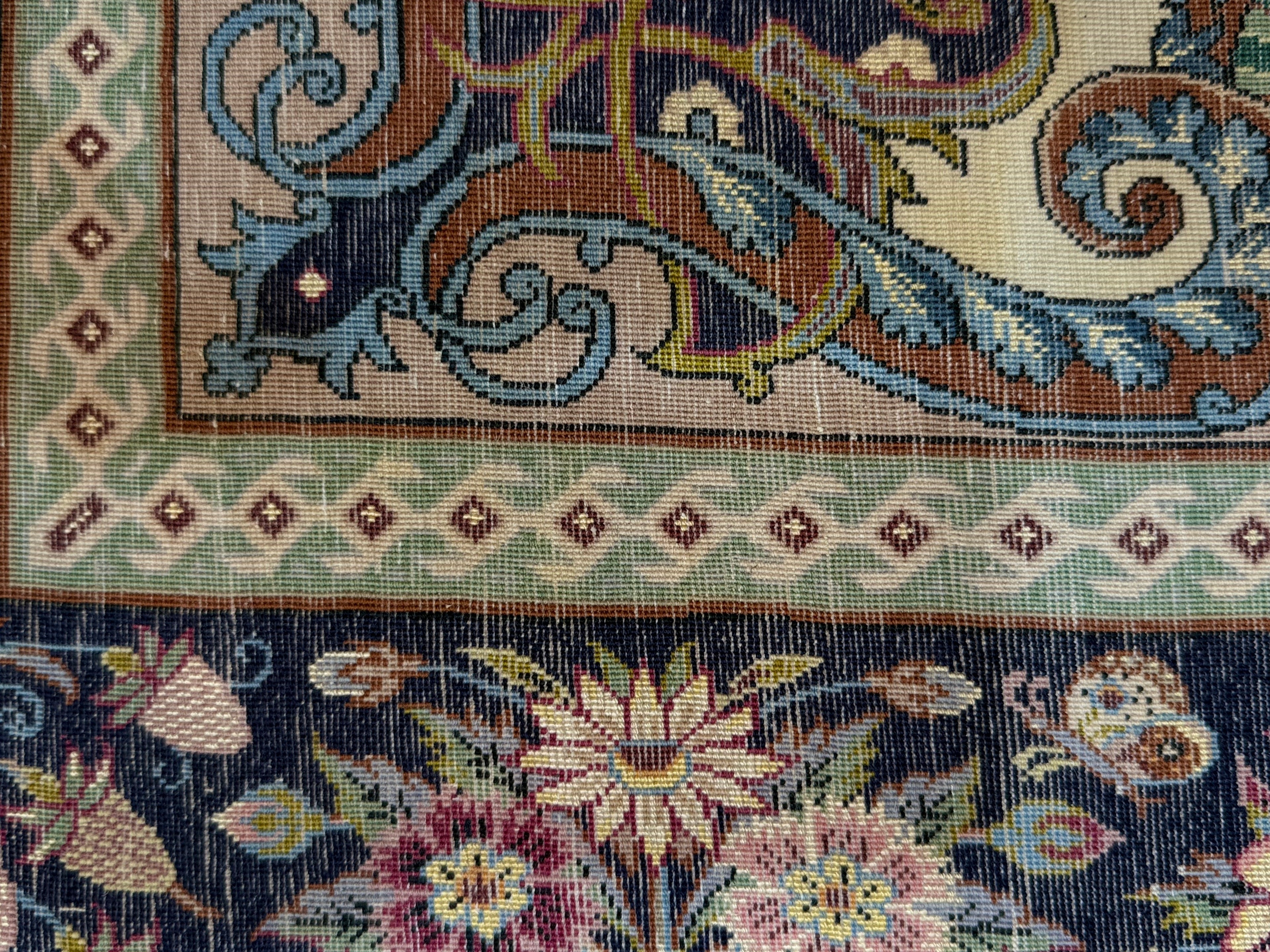 Close-up of a detailed tapestry with floral and paisley patterns.