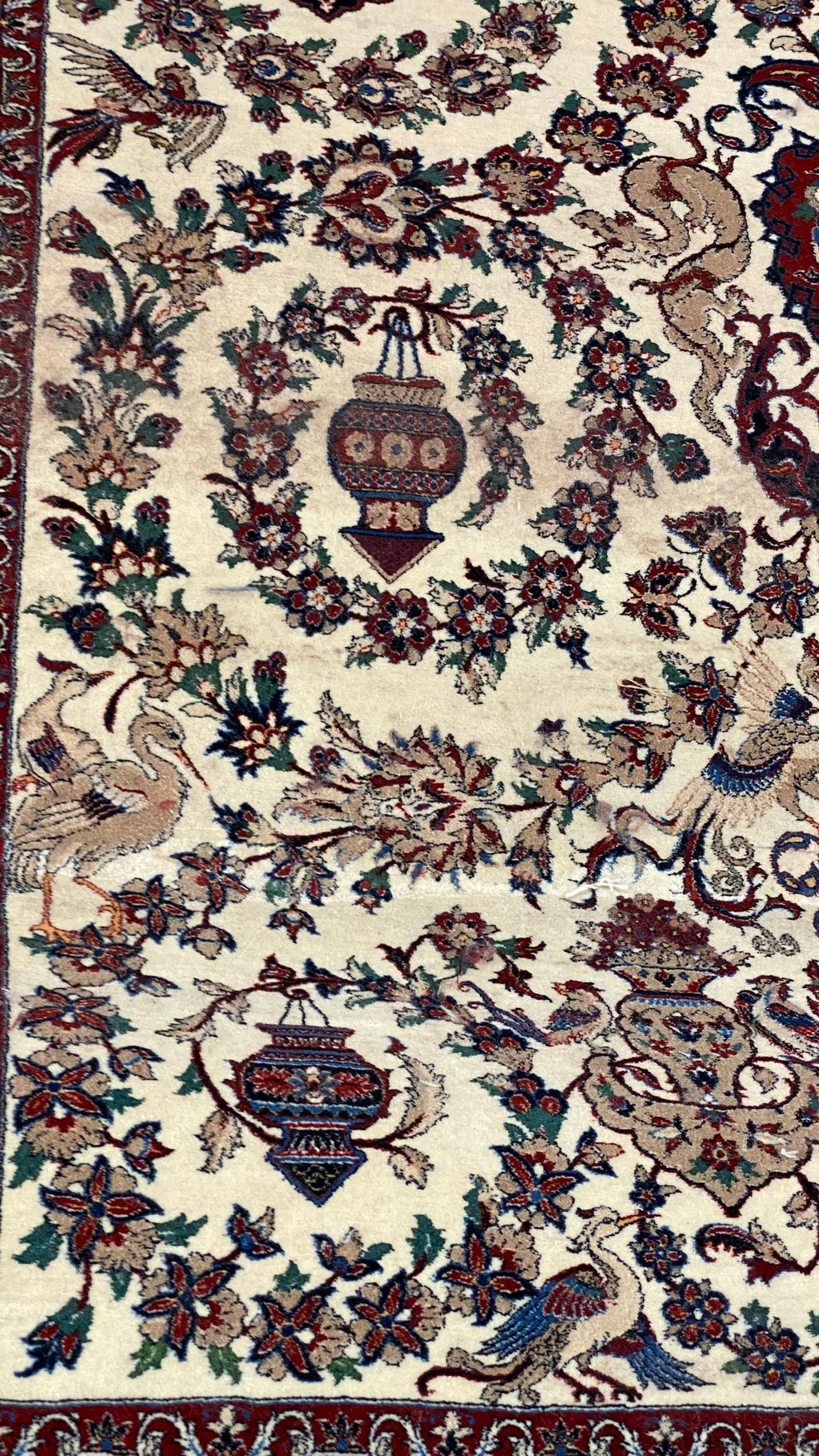 Decorative rug with intricate floral and bird patterns on a beige background