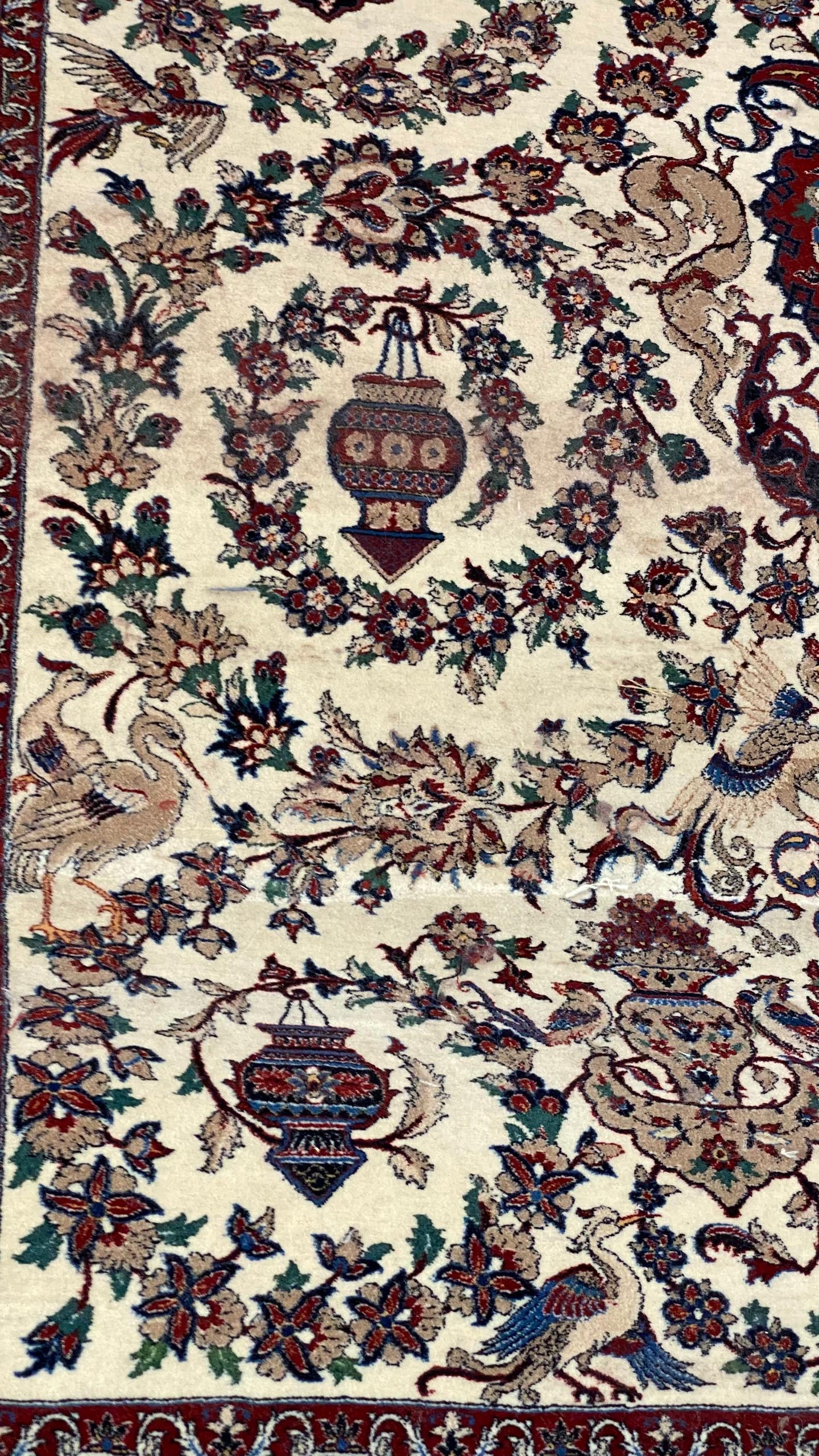Decorative rug with intricate floral and bird patterns on a beige background