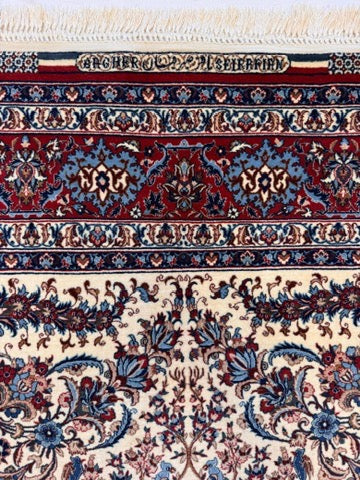 Close-up of a patterned rug with intricate designs in red, blue, and beige.