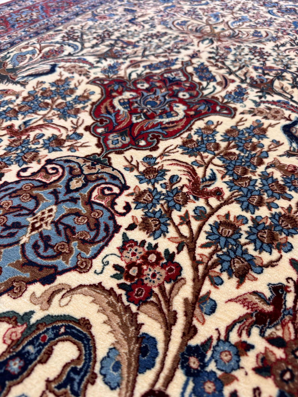 Close-up of a patterned rug with intricate designs featuring flowers and paisleys.
