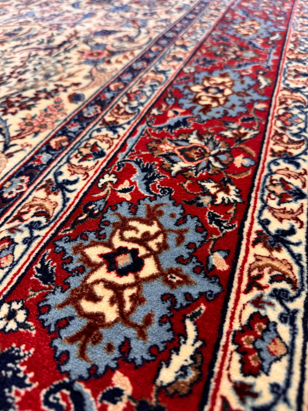 Close-up of a patterned red and blue rug with intricate designs.