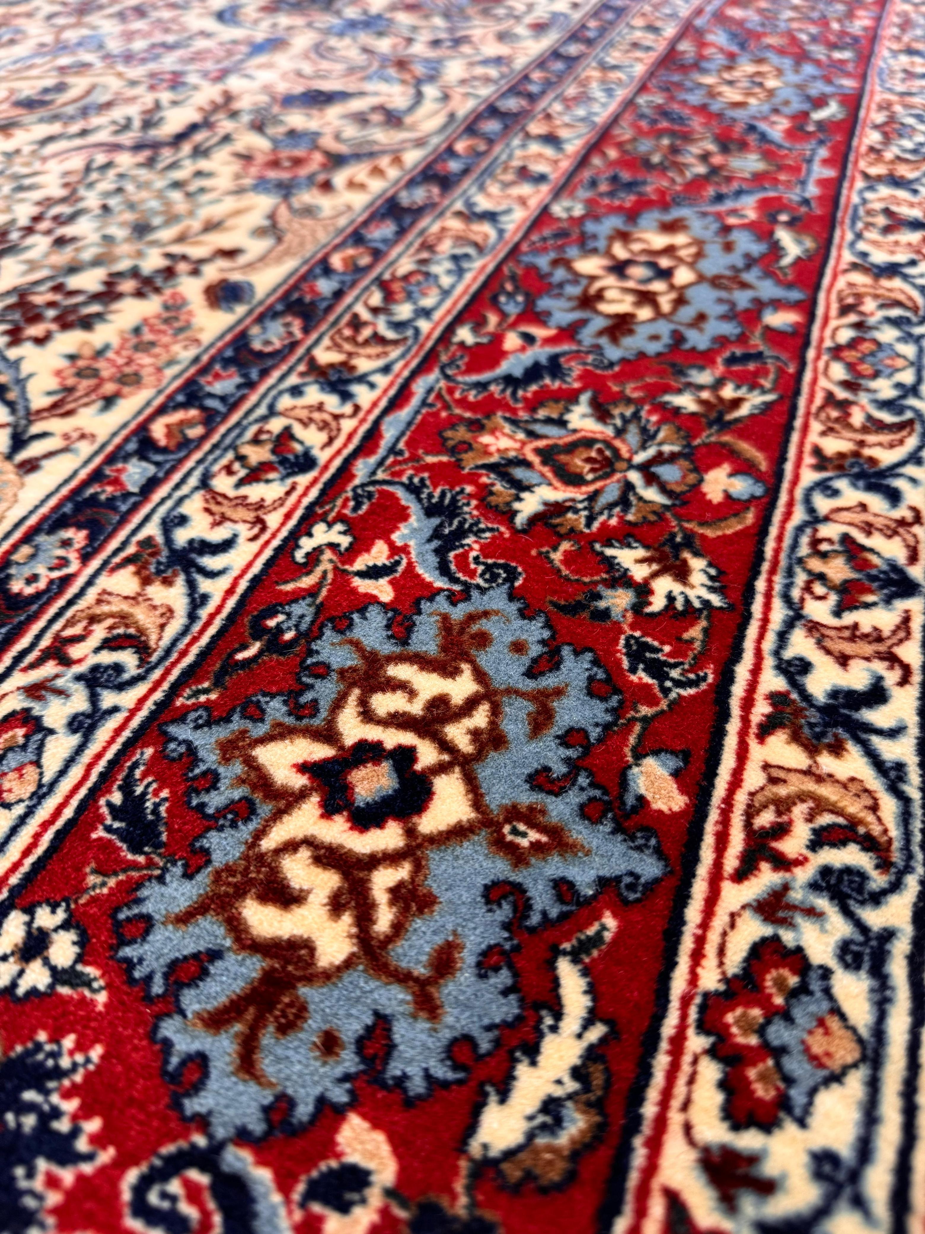 Close-up of a patterned red and blue rug with intricate designs.