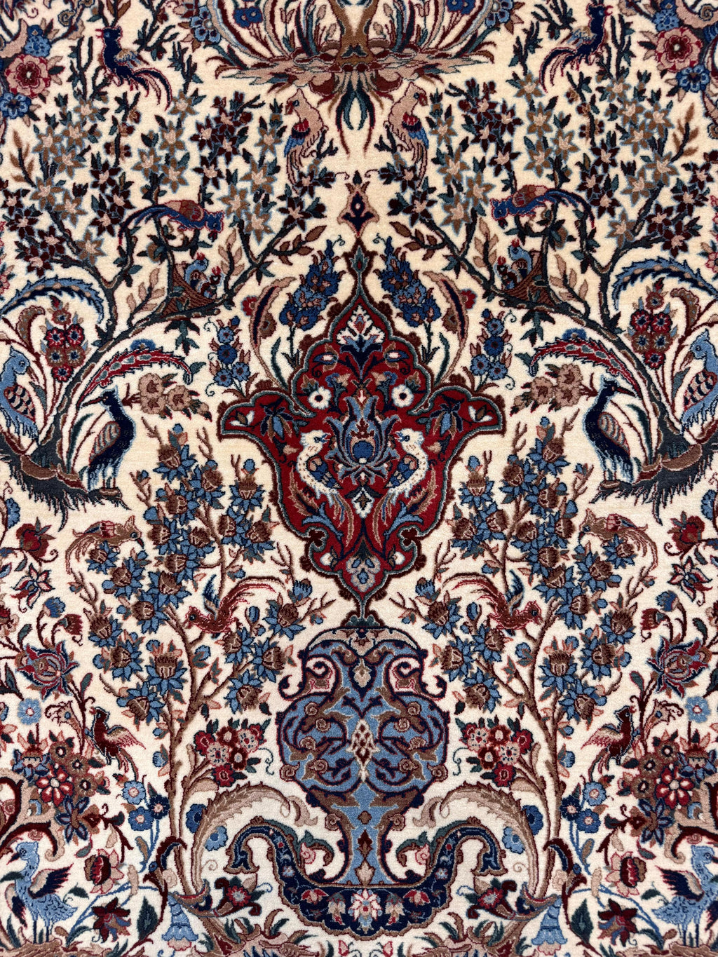 Decorative patterned fabric with intricate designs in red, blue, and beige.