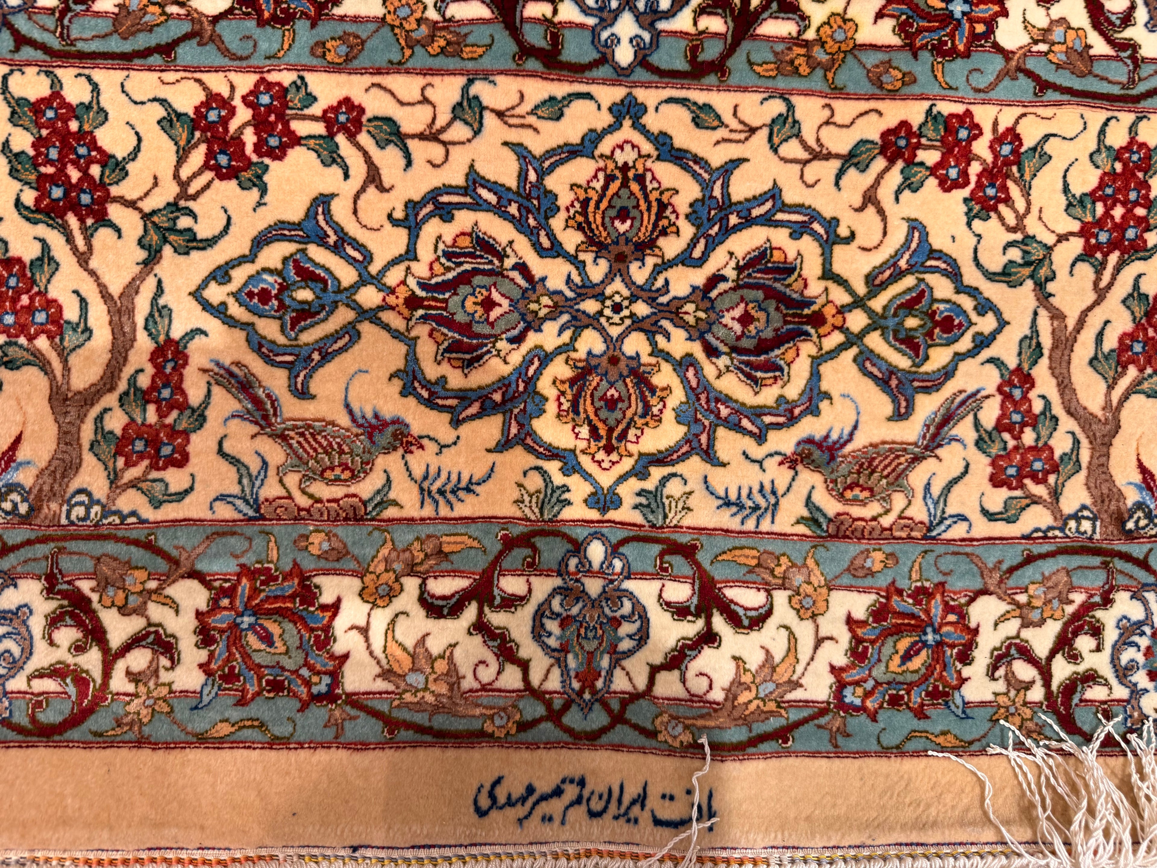 Close-up of a intricately designed rug with floral and animal patterns.