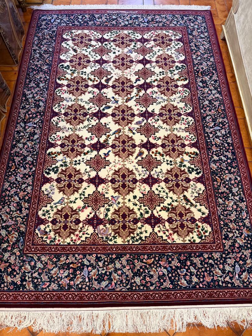 Decorative rug with intricate patterns on a wooden floor، Isfahan carpet