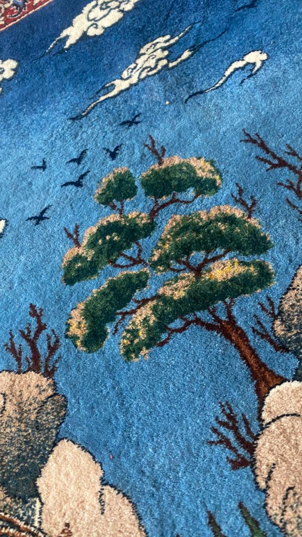 Close-up of a rug with tree and cloud patterns