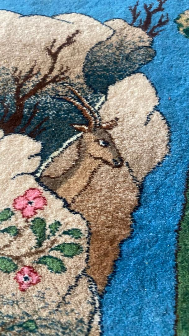 Close-up of a rug with a deer and floral design